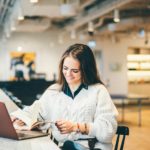 Businesswoman working on laptop in modern coworking.