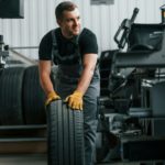 In uniform. Man is working in the auto service