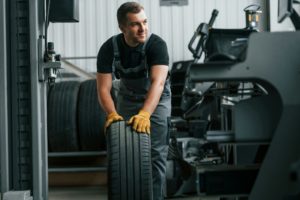 In uniform. Man is working in the auto service